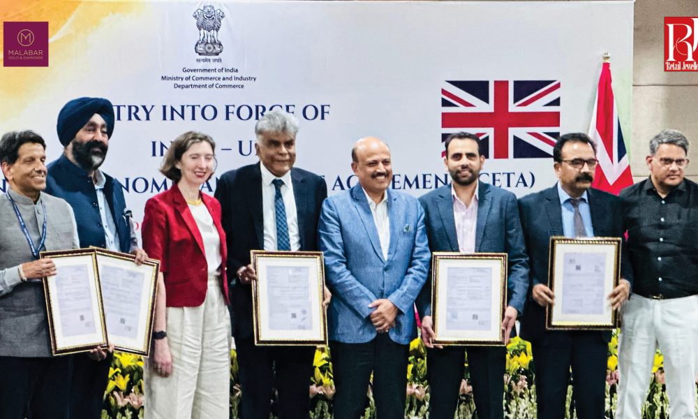 Government officials and industry representatives mark the entry into force of the India–UK CETA while holding framed trade documents.